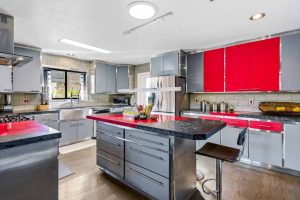 Modern kitchen with an island with gray and red accents.