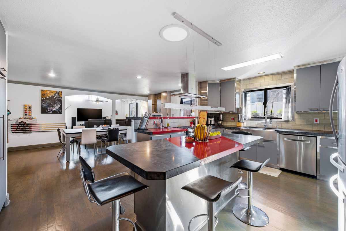 Modern kitchen space with gray island, all looking out to the dining and living room.