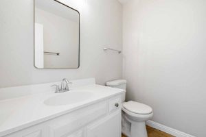Half bathroom with a toilet and white vanity.