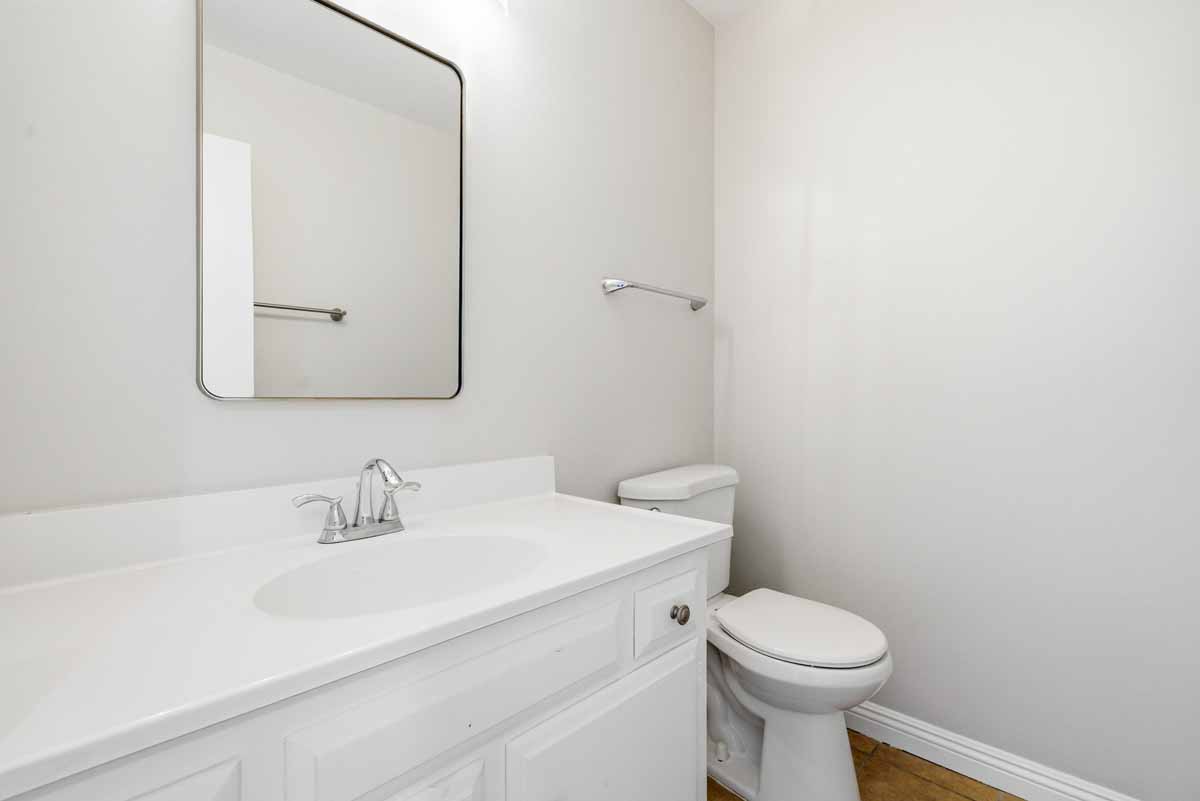 Half bathroom with a toilet and white vanity.