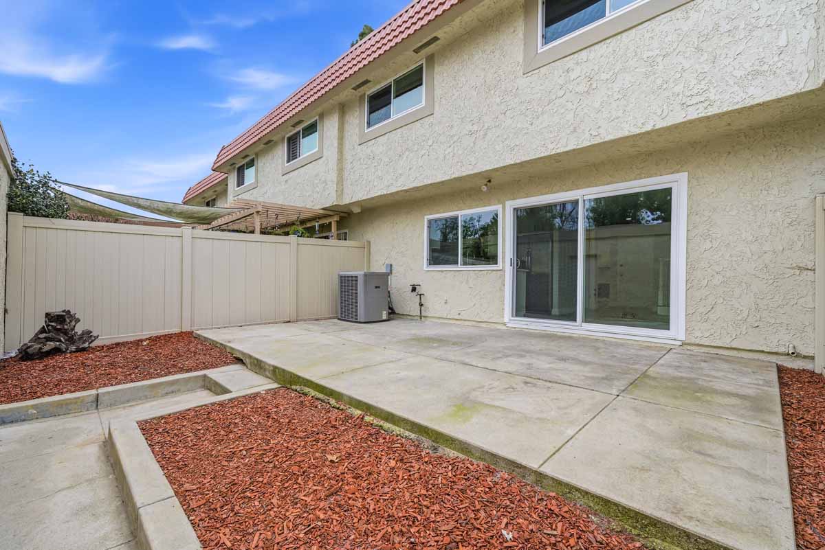 Low maintenance patio with a sliding glass door and a concrete pad.