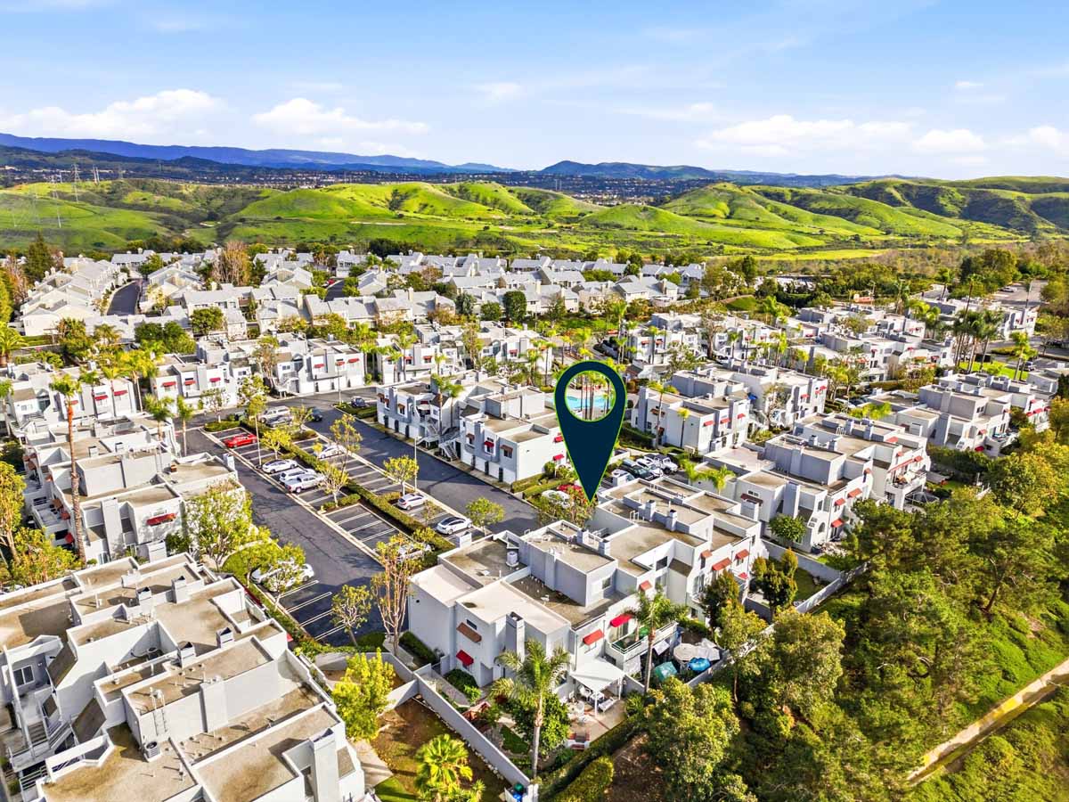Aerial view of condo complex surrounded by lush greenery. There is an arrow pointing to 27743 Zircon, Mission Viejo.
