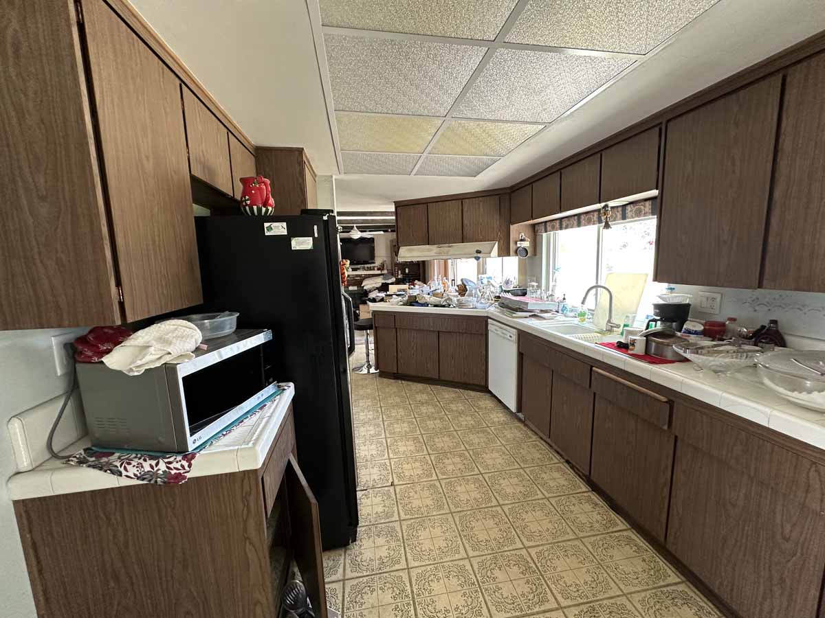 Outdated galley-style kitchen with linoleum floors.