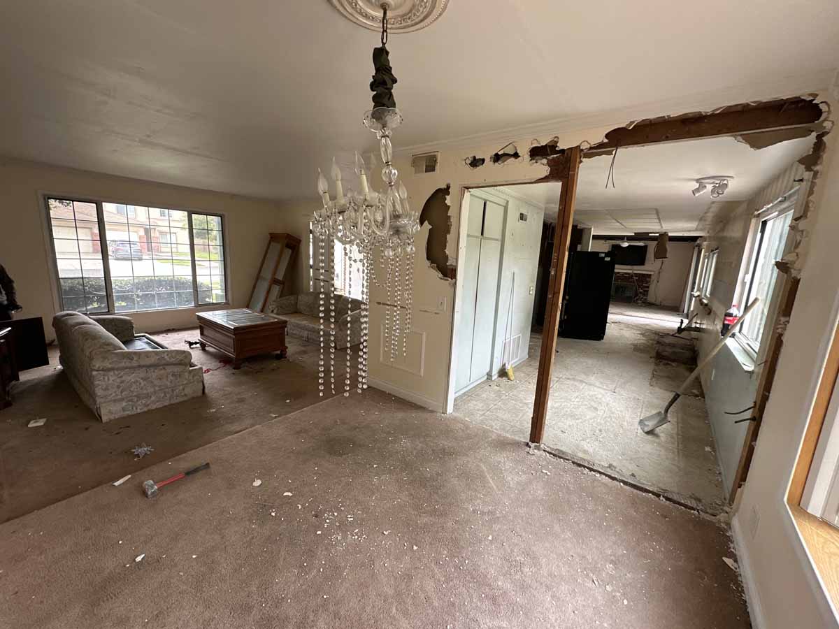 Early staged of demolition in an outdated home showing wall being opened up.