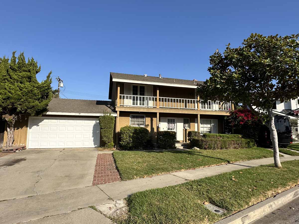 Front view of 18954 Santa Marta Street showing large driveway leading to a 2-car garage and off to the side is a second level balcony that stretches the length of the front.