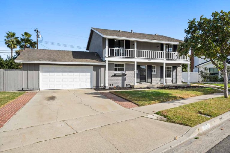 Front view of home showing fresh gray paint with white garage door and white trim.
