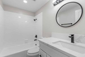 Updated bathroom with new white vanity with white stone counters.