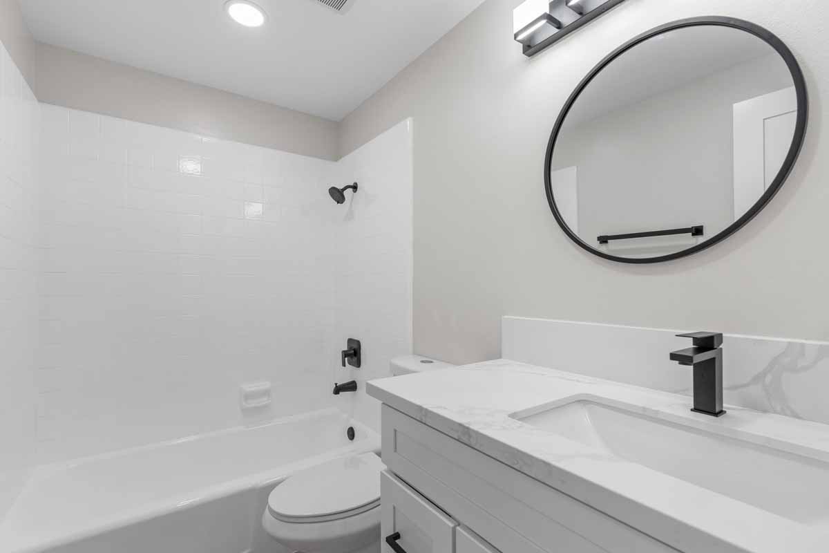 Updated bathroom with new white vanity with white stone counters.