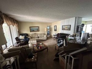 An outdated living space with couches, a piano, drapes and shag carpet.