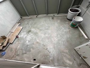 An old worn down concrete patio with building materials off to the side.