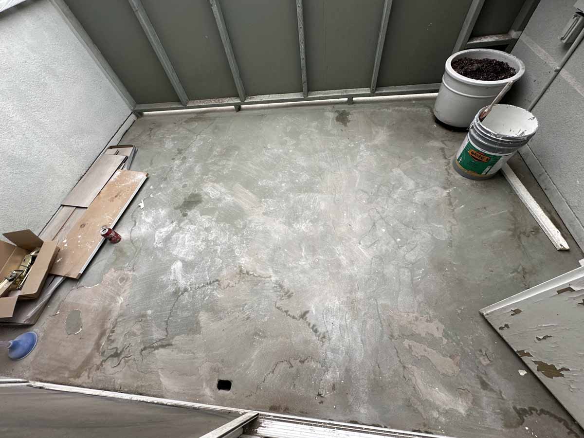 An old worn down concrete patio with building materials off to the side.
