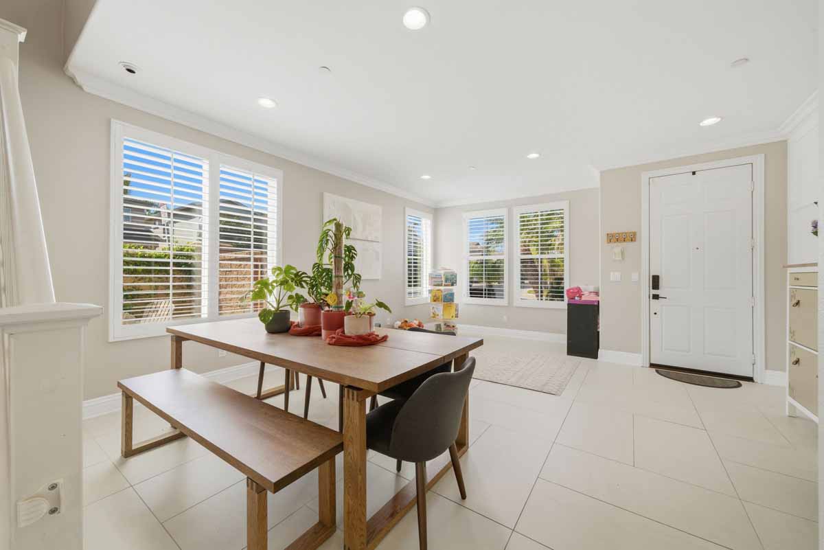 Dining table with view of front door and a wall of windows.