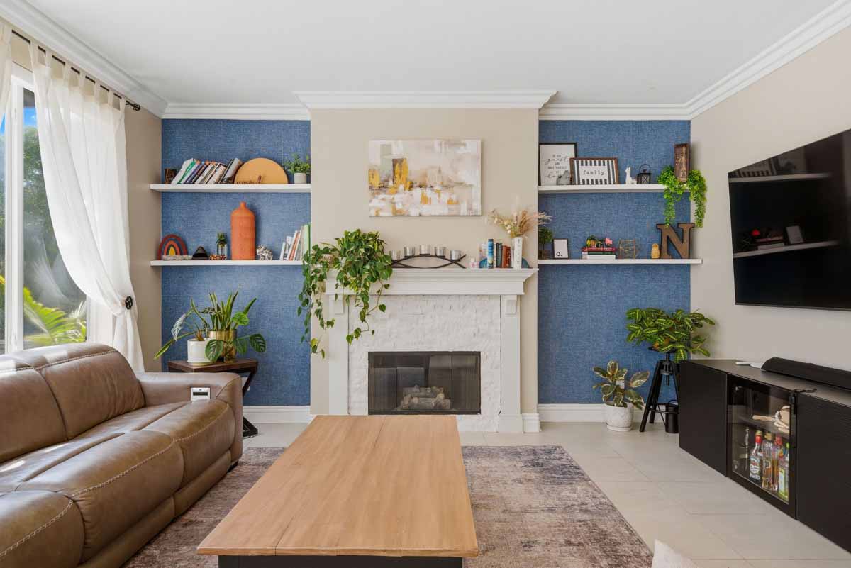 Living room with blue accent wall behind a white fireplace.