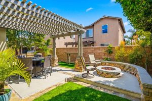 Backyard with covered pergola and a firepit.