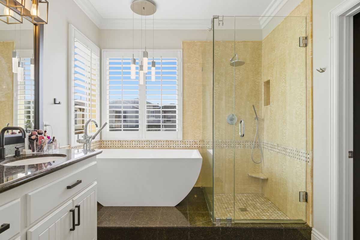 Master bathroom with a soaking tub, a walk-in shower, and white double vanity.