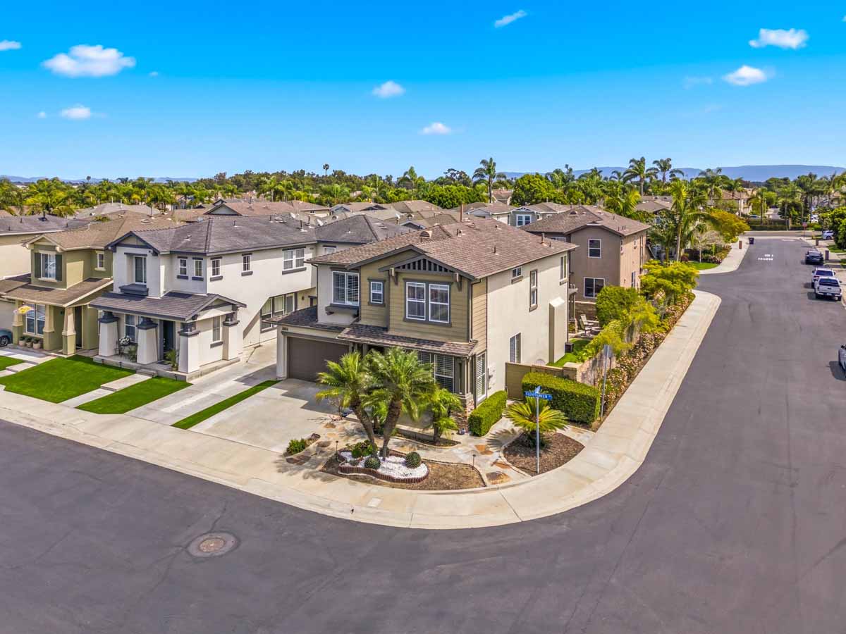 View of front of home from an elevated level showing a two story home on the corner lot.