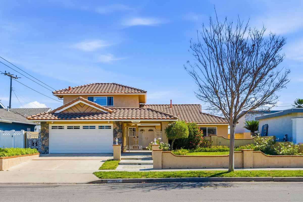 Exterior view of 19022 Summerfield Lane, Huntington Beach with tan painted stucco and a white garage door.
