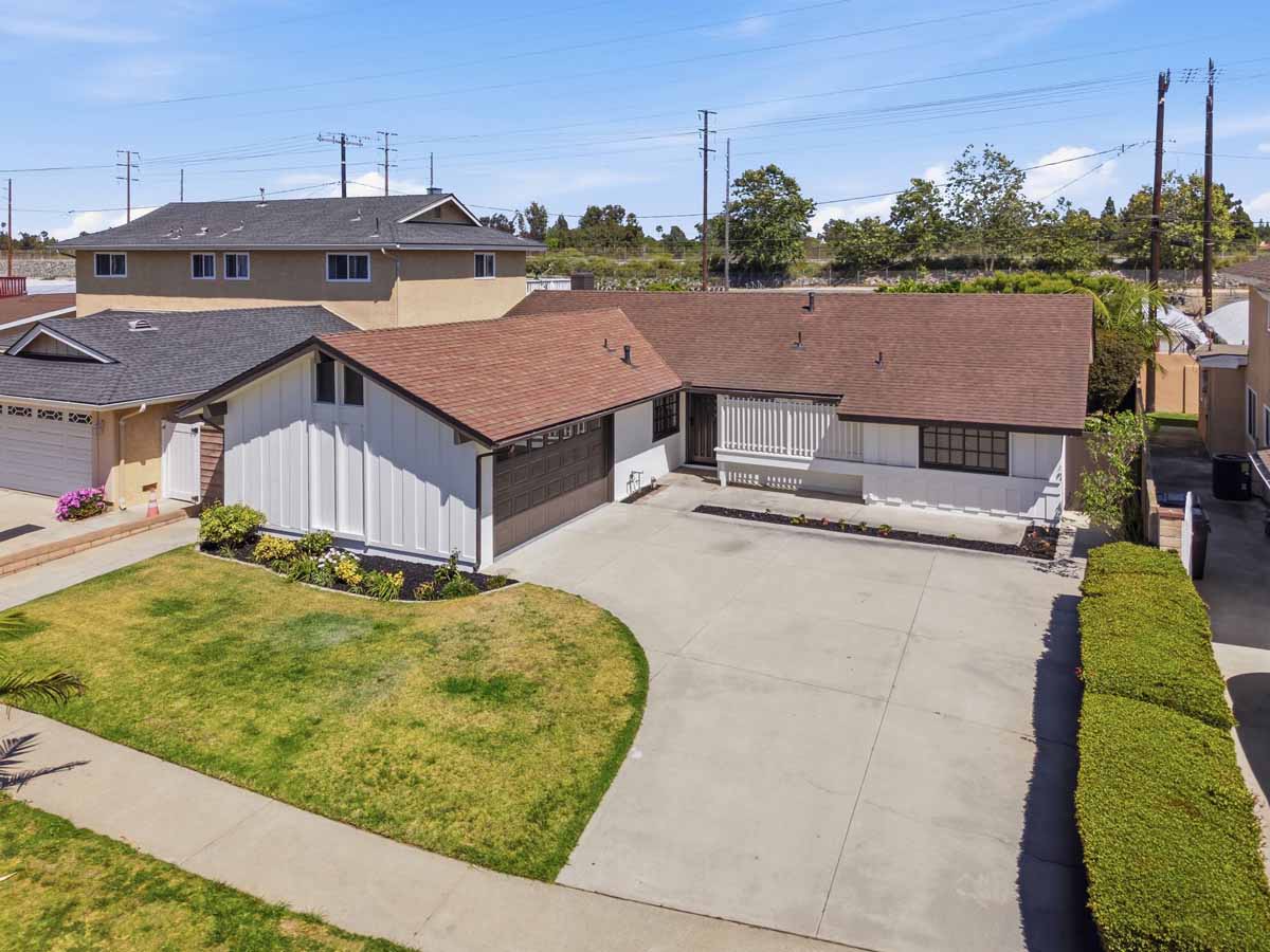 Front of one-story home with white paint and a tan roof.