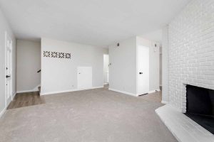 Updated living room with new neutral colored flooring and fresh light-colored painted walls.
