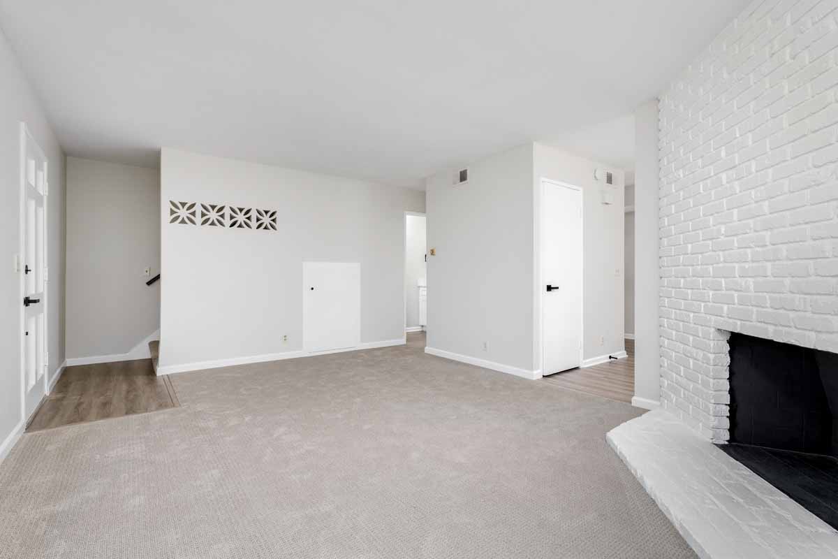 Updated living room with new neutral colored flooring and fresh light-colored painted walls.