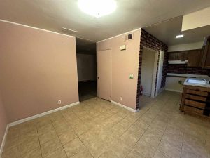 Dark, outdated dining area with brown walls and beige tile flooring.