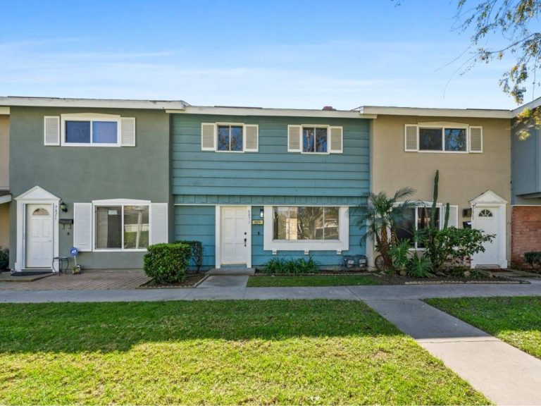 Blue painted exterior of front of two-story townhouse at 9871 Cornwall Drive, Huntington Beach.