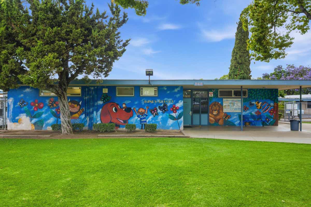 An elementary school with a blue mural painted along the front showing Clifford the Big Red Dog.