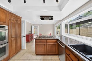 Galley style kitchen with wood-toned cabinetry and stone counter tops.