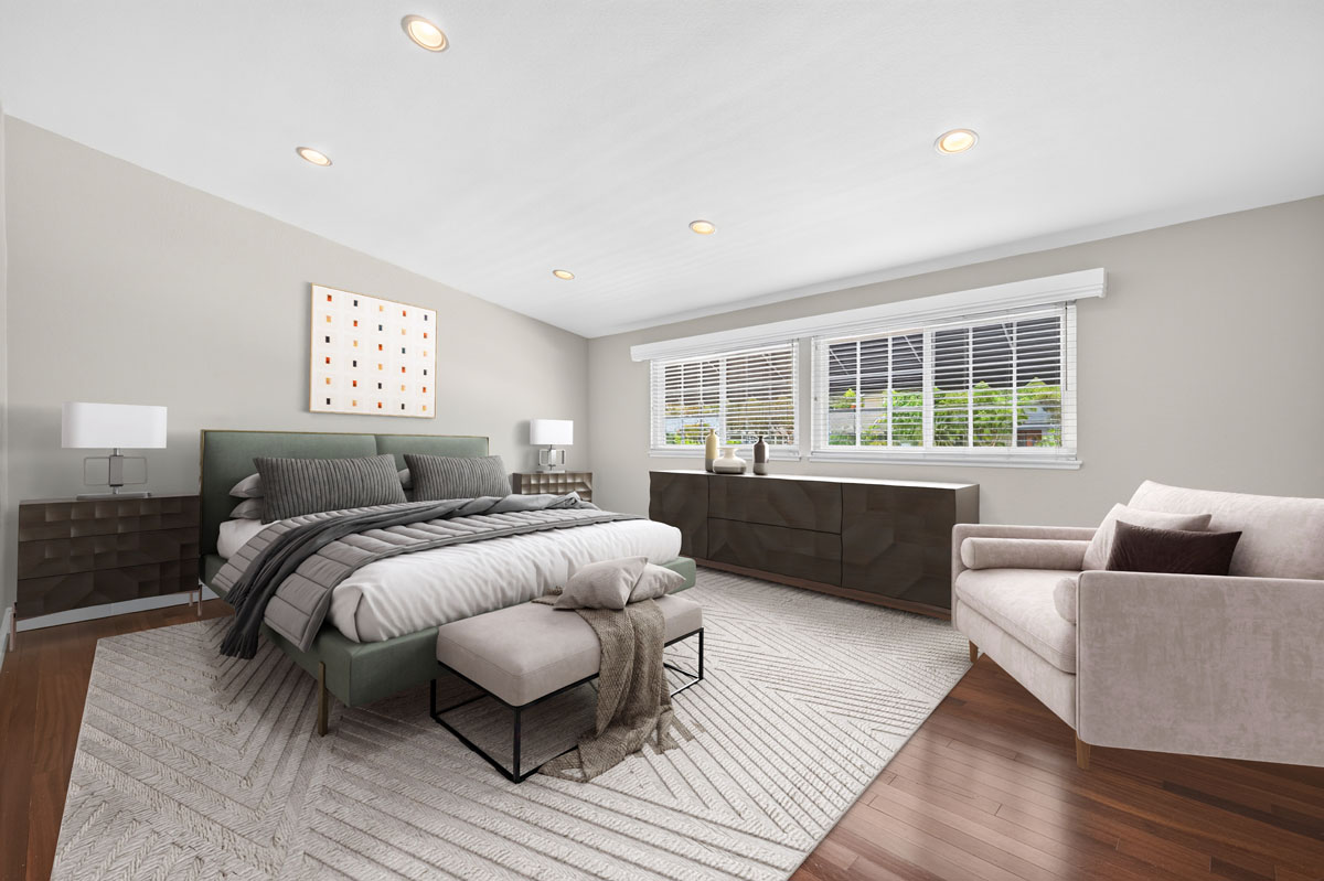 Digitally staged master bedroom with a bed, dresser, chair and large bright window.