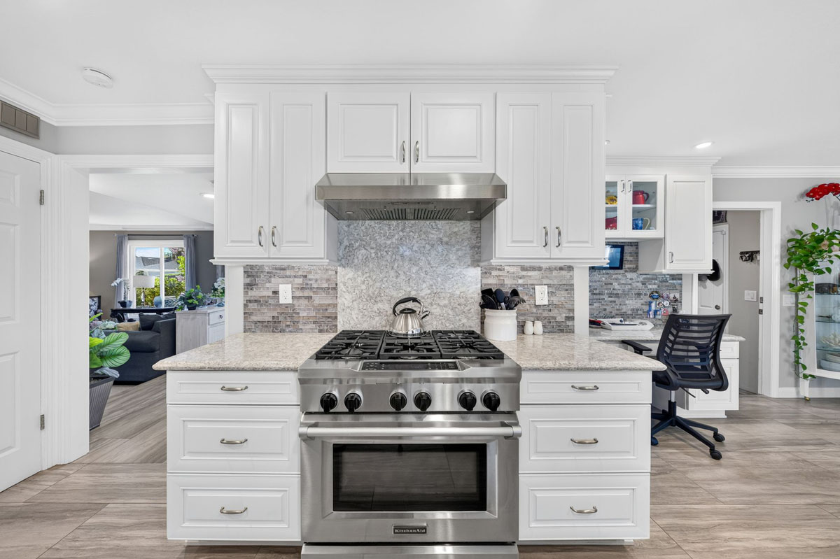Updated white kitchen with large stainless steel range.