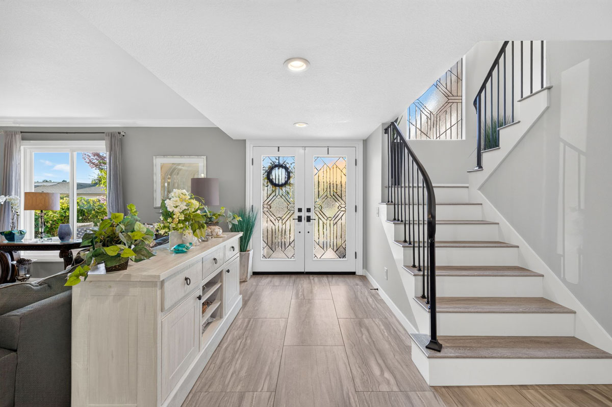 Entry way inside 8938 Martin Avenue, Fountain Valley showing double doors, a staircase and canned lights.