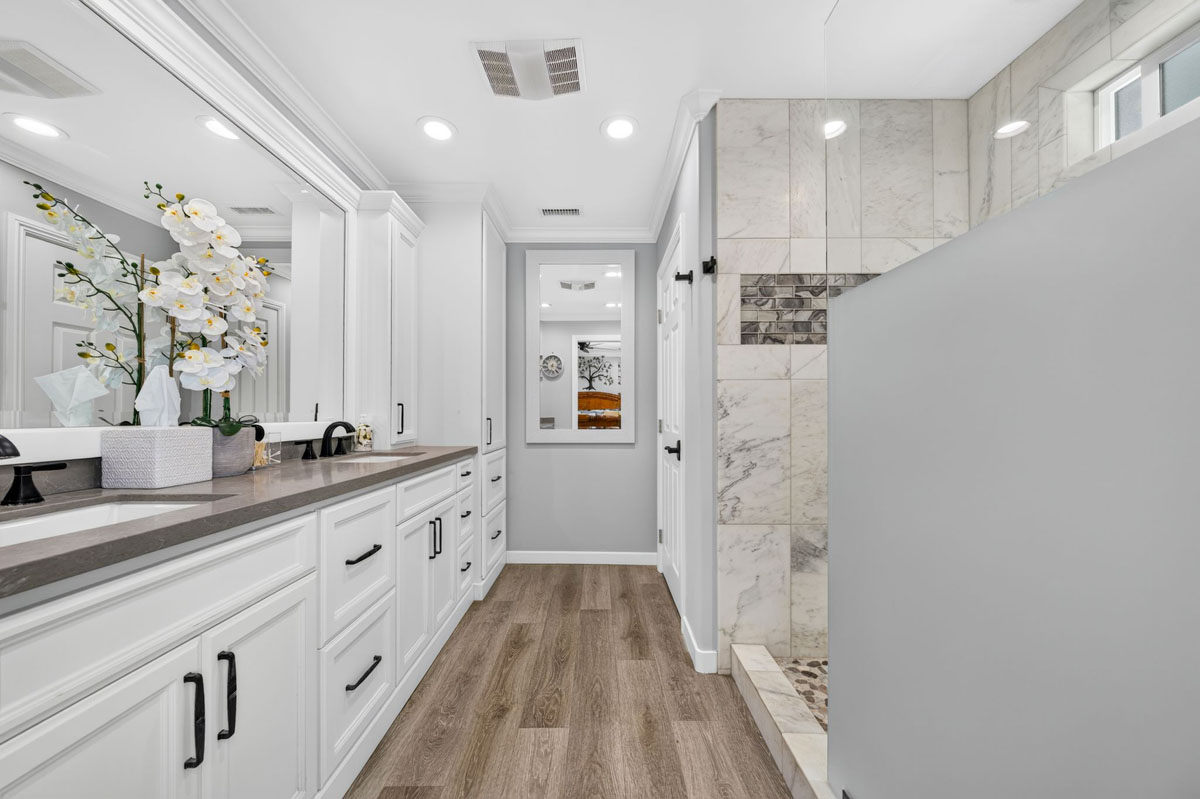 Updated master bedroom with light neutral colors and stone finishes.