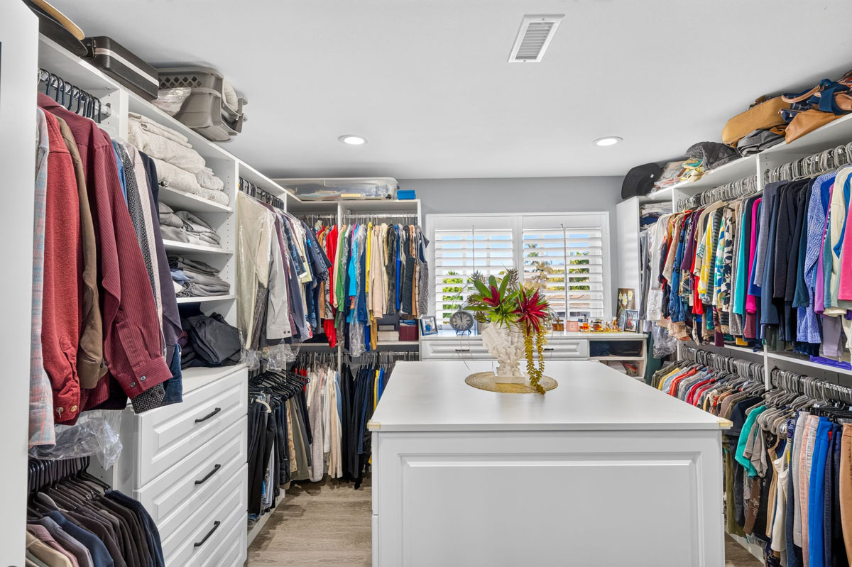 Large walk in closet with a window and center island.