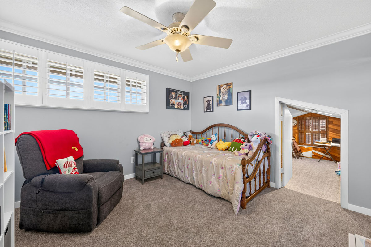 Bedroom with neutral paint on walls and a ceiling fan.