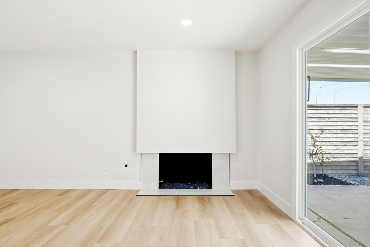 Bright remodeled living room with a white fireplace at 19562 Aragon Circle in Huntington Beach.