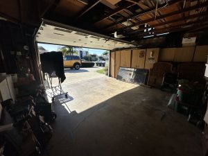 Original garage space with stained concrete and a wall of cabinets in the back.