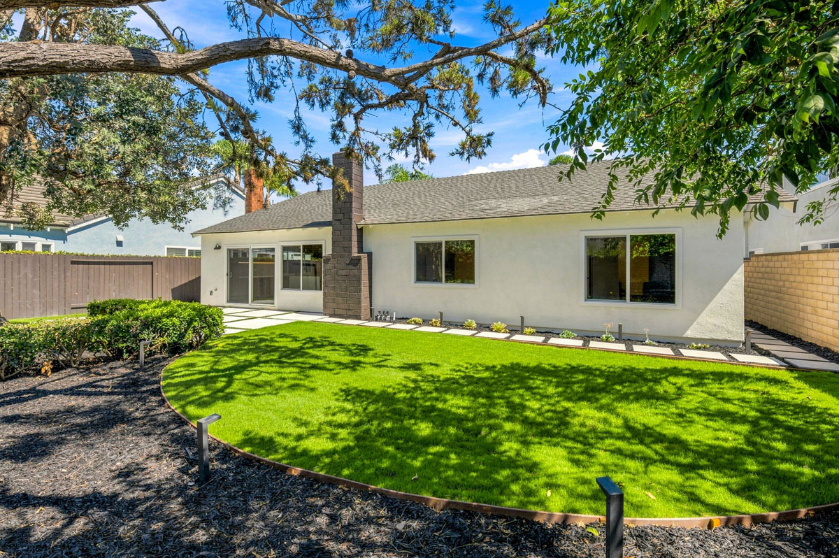 Backyard space with new sod and fresh paint on house.