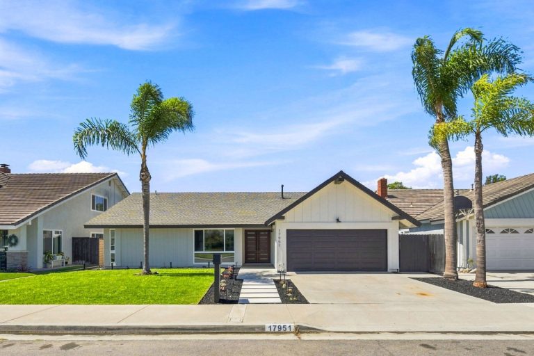 Front of one-story house with white paint and brown painted garage door.