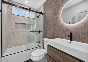 Updated hall bathroom with back-lit circular mirror.