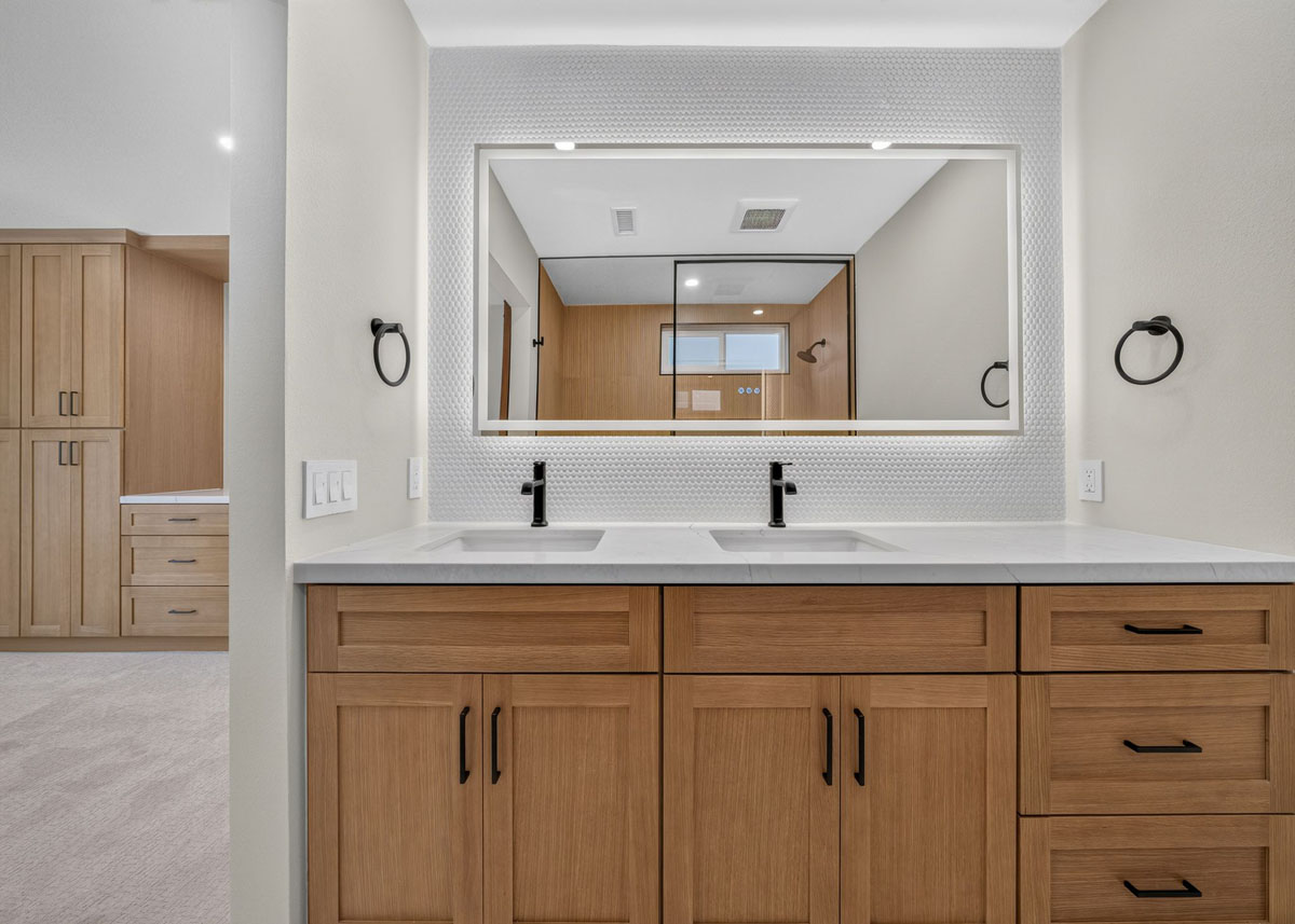 Updated master bathroom with wood toned cabinetry.
