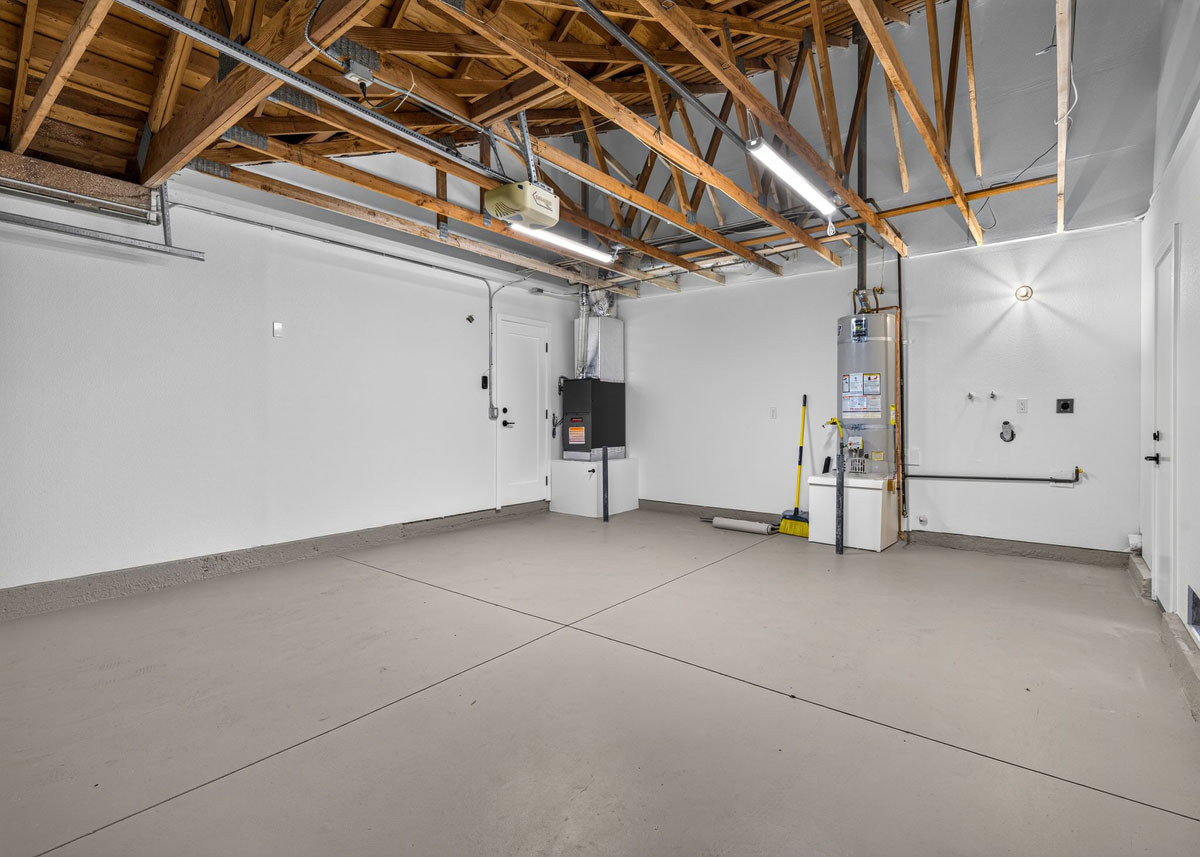 Empty garage space showing open rafters in the ceiling.