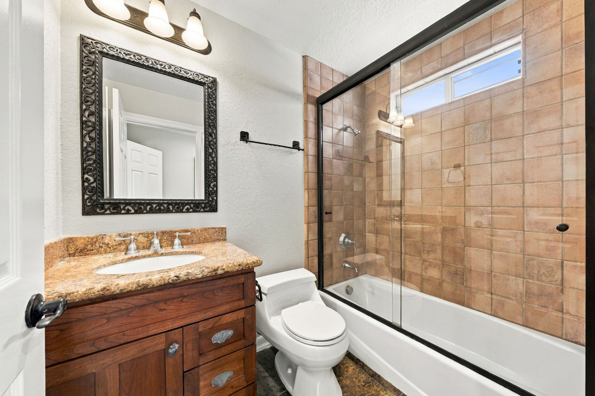 Full bathroom on the first floor featuring a single sink vanity, toilet, and a walk-in shower/tub combo.