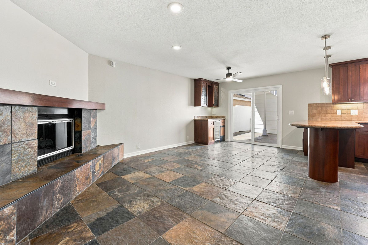 Living room off the kitchen with a fireplace, drybar, and a sliding door leading to the yard.